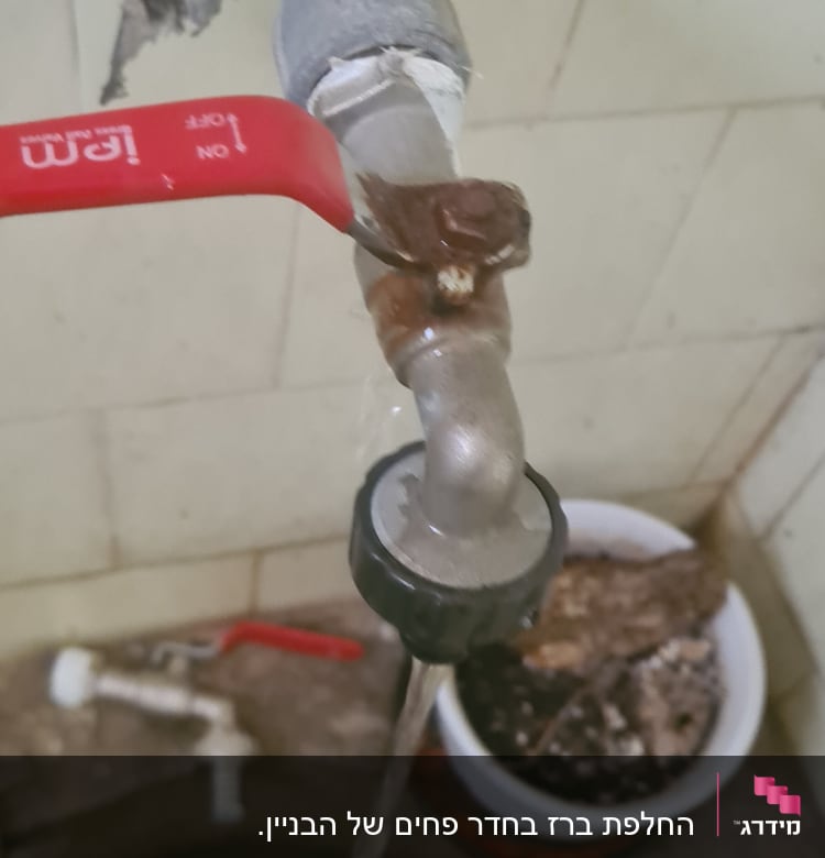 ברז מים עם ידית אדומה, צינור חלוד